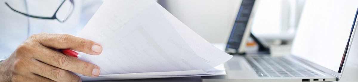 zbliżenie na dłoń trzymającą stos papierów